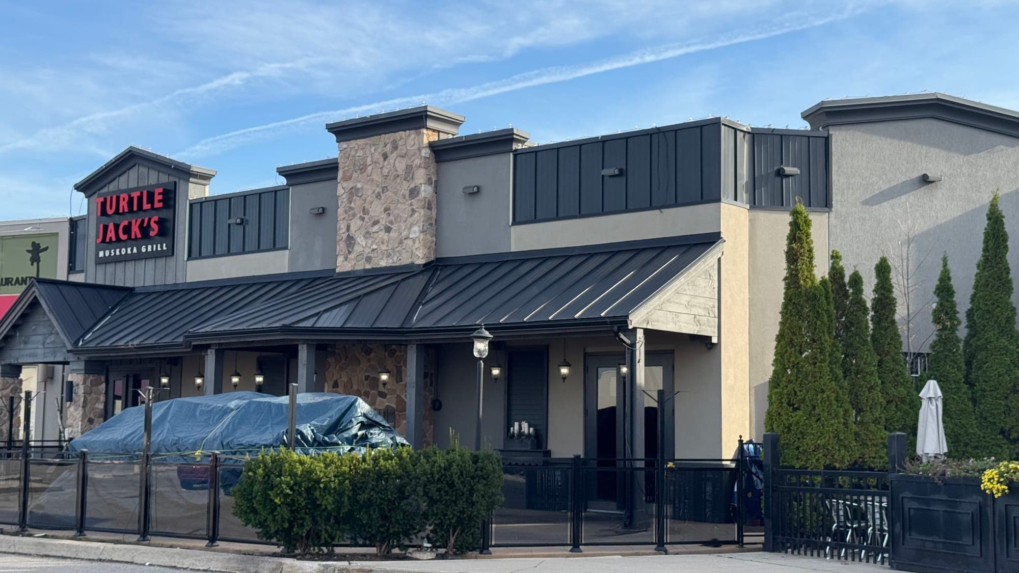  A building with a side patio features the words Turtle Jack’s Muskoka Grill in capital letters.