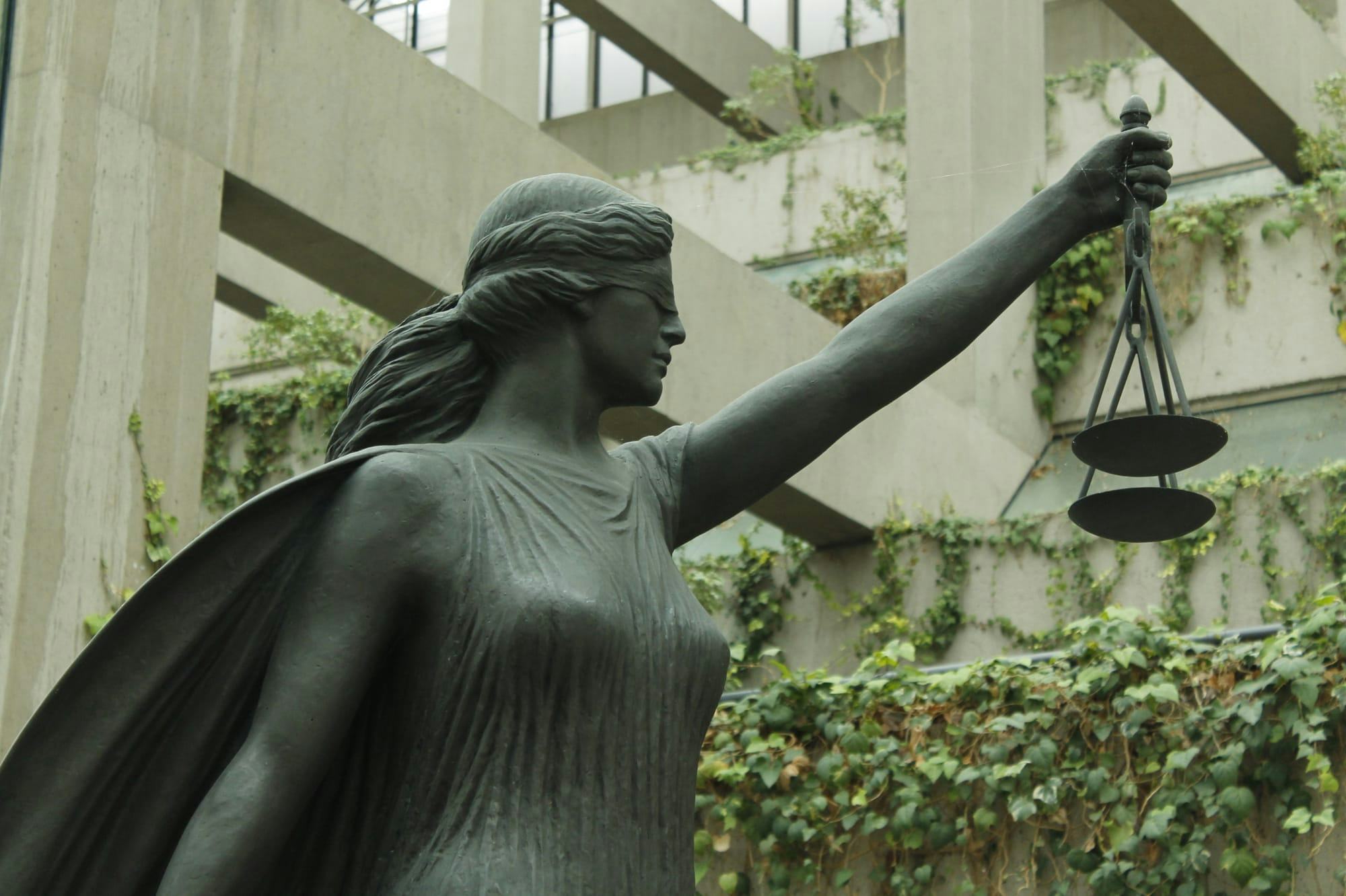 A metal statue of a Greek goddess holds a set of metal scales in the B.C. Supreme Court. 