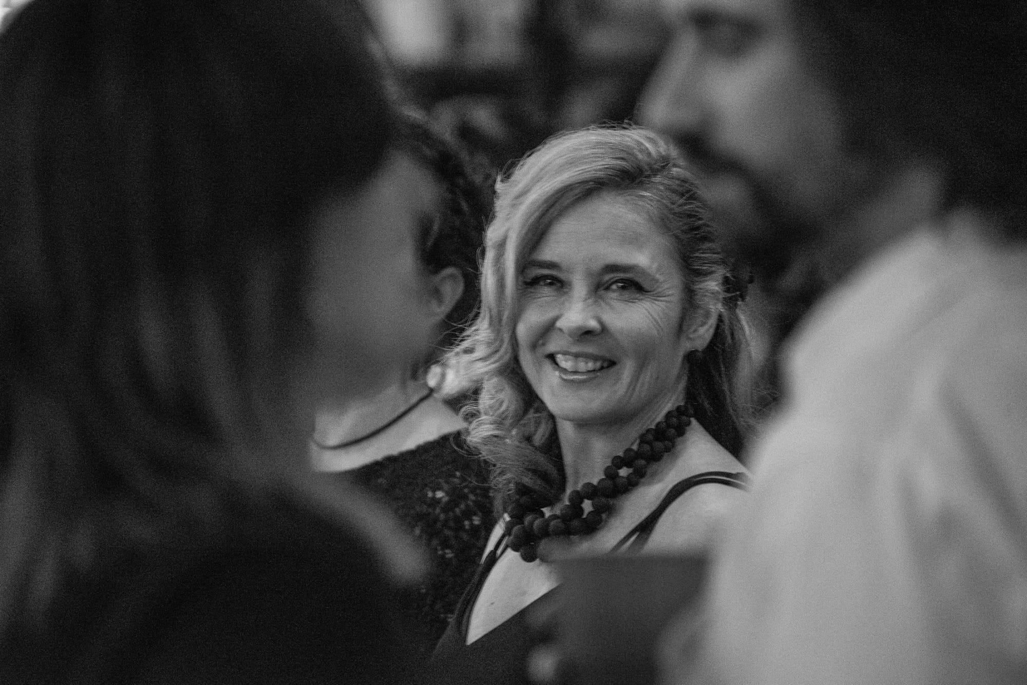 Bobbi Leach is shown from the shoulders up in a black and white photo taken at a RevenueWire Christmas party in 2017.