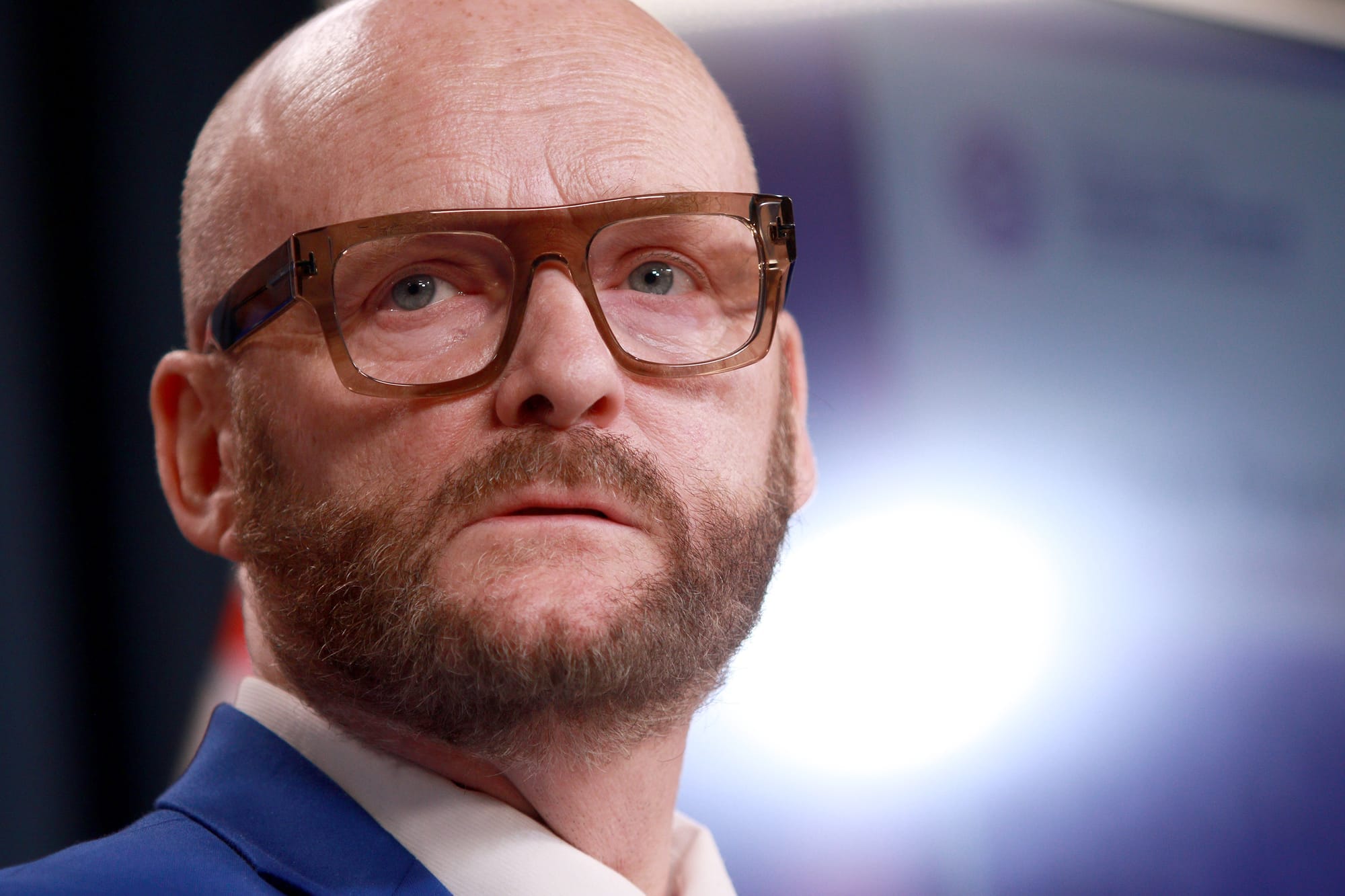 B.C. Auditor General Michael Pickup wears thick-framed glasses and looks to his right during a press conference.