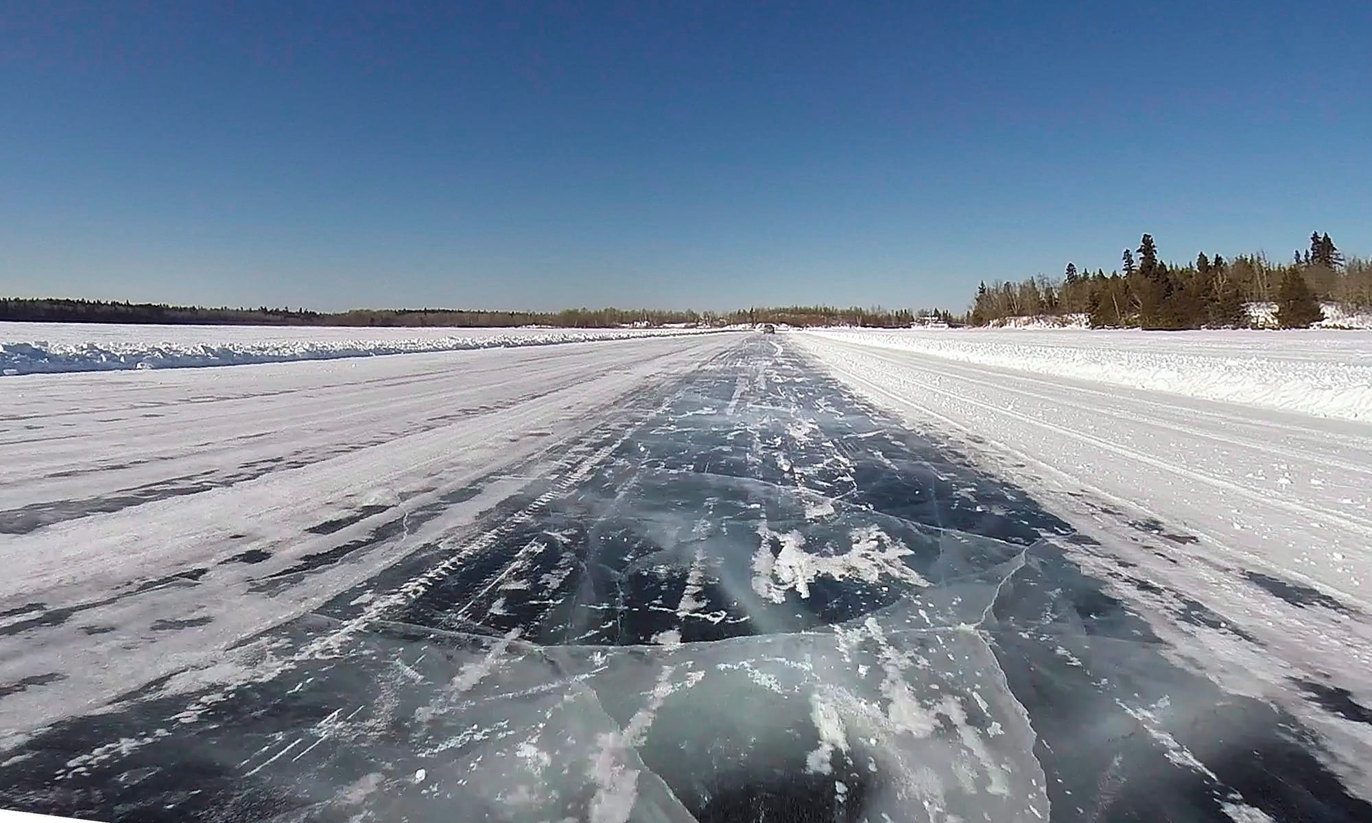 A winter road is shown with blue skies above.