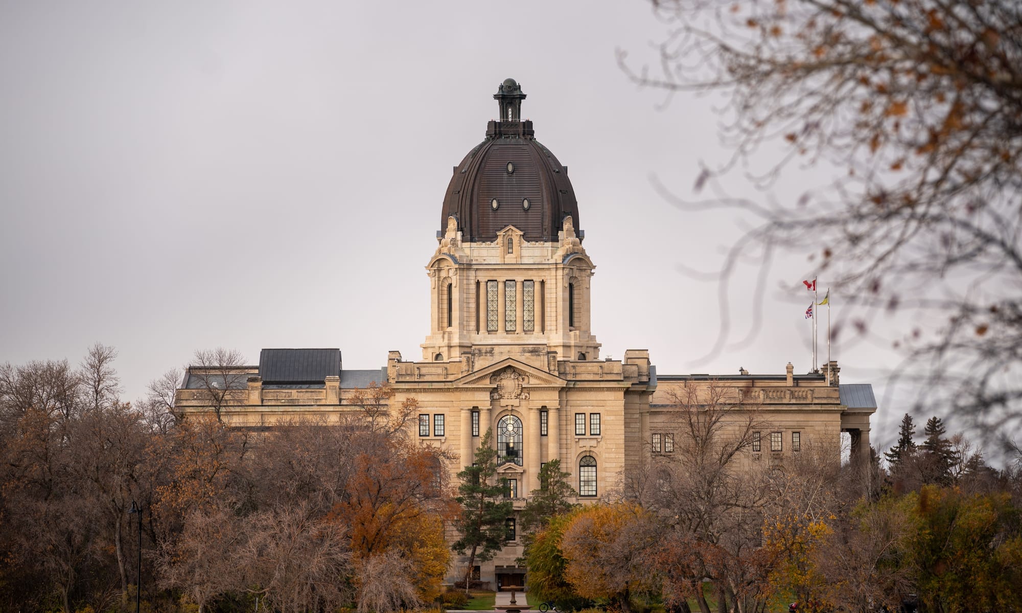 The Saskatchewan legislature is surrounded by mostly bare trees in late October.