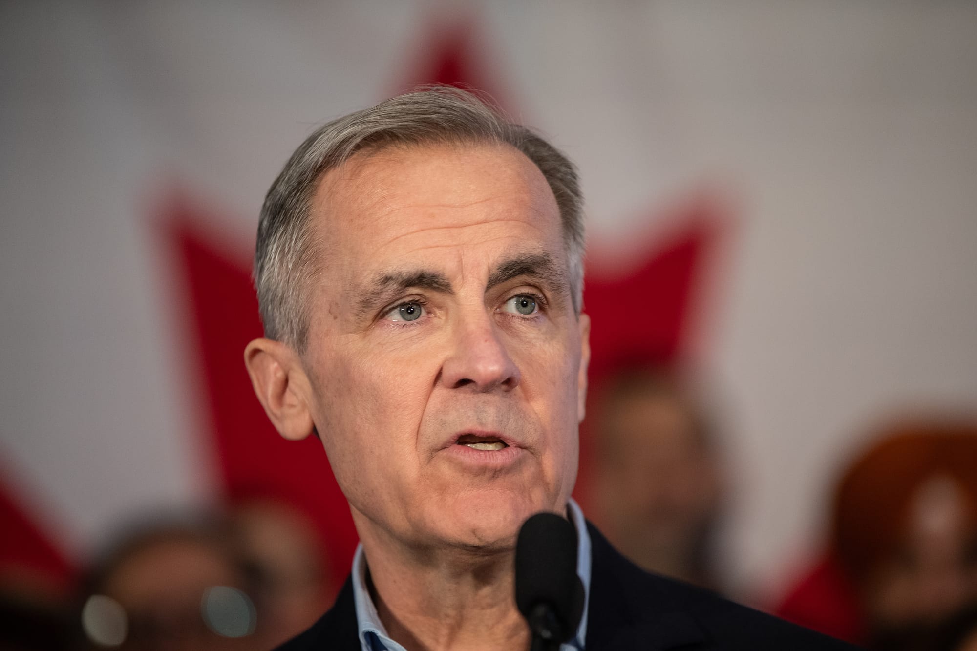 Mark Carney looks off into the distance as he speaks to a crowd.