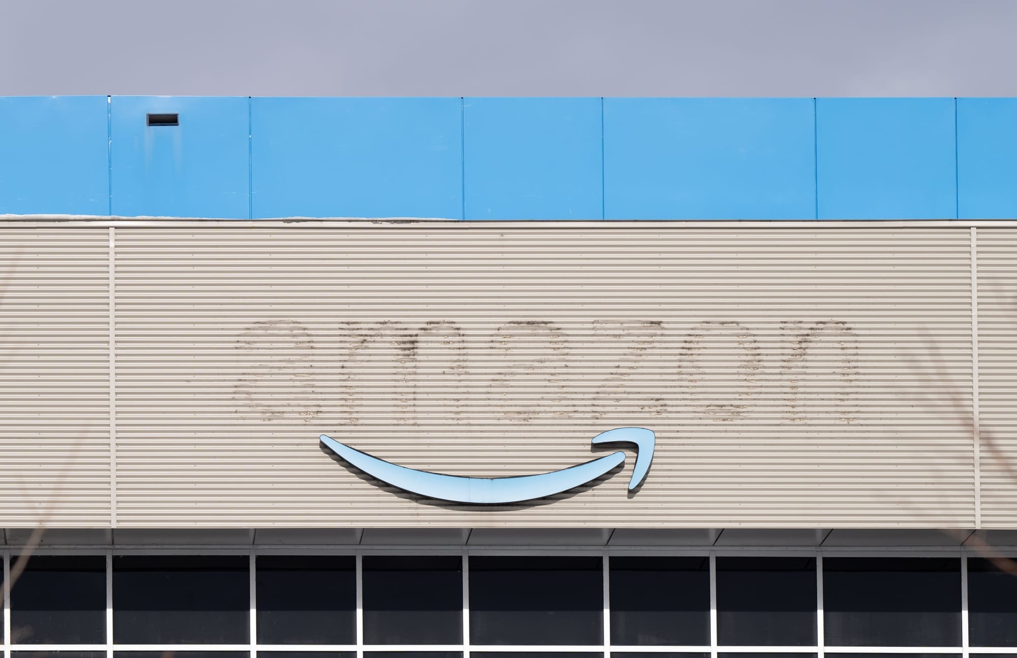 A former Amazon warehouse has has removed so only a shadow of the company's name remains. 