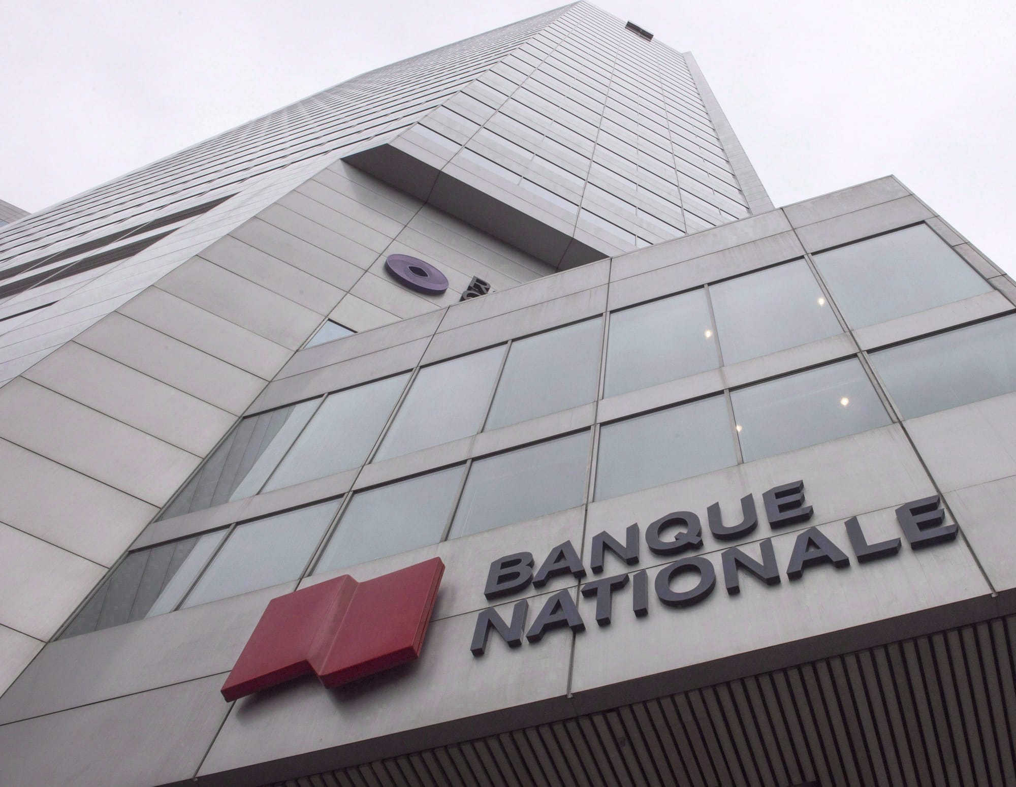 A concrete and glass tower features the logo for National Bank
