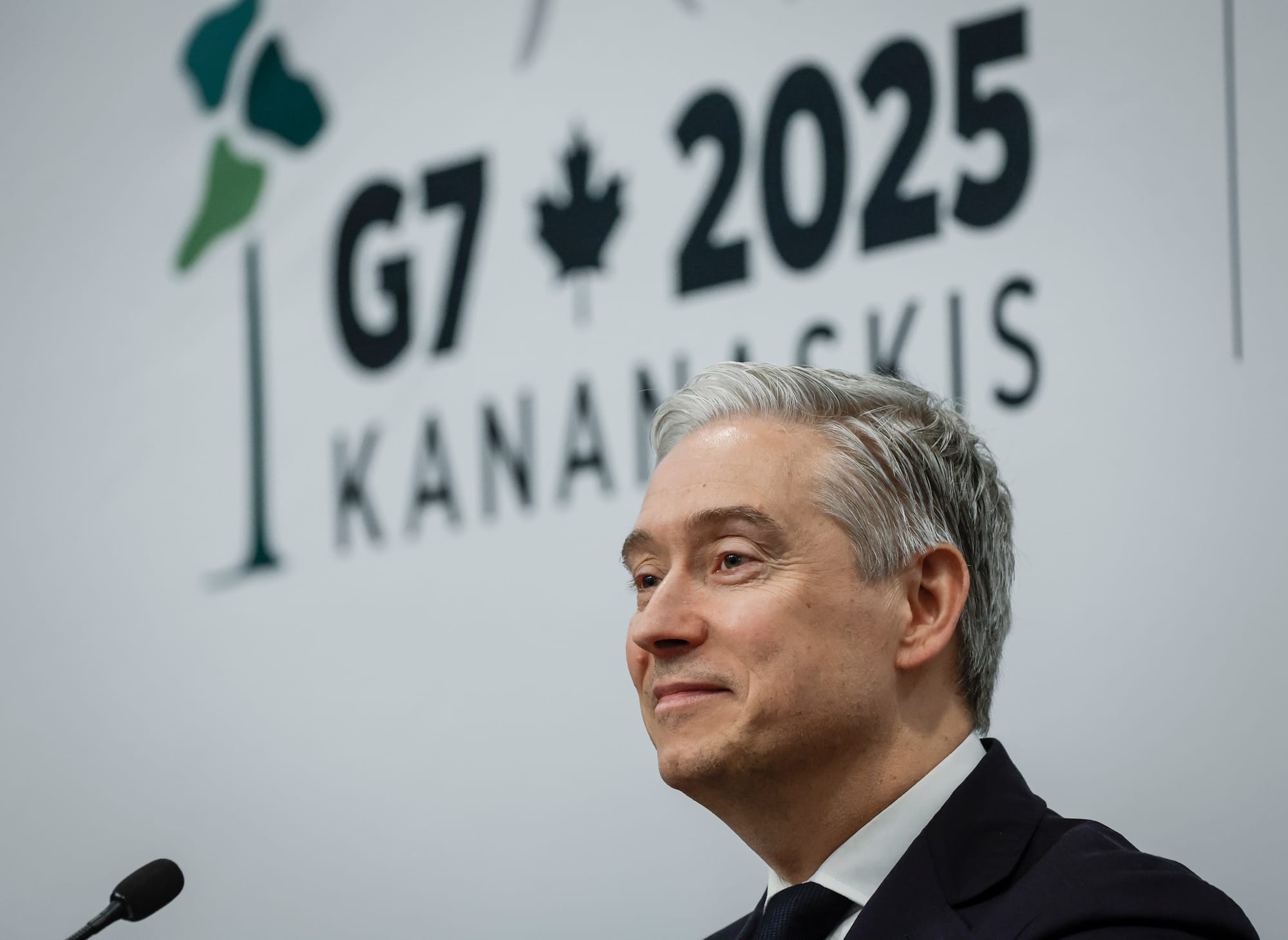A close up of Francois-Philippe Champagne standing in front of a sign that says G7 2025 KANANASKIS