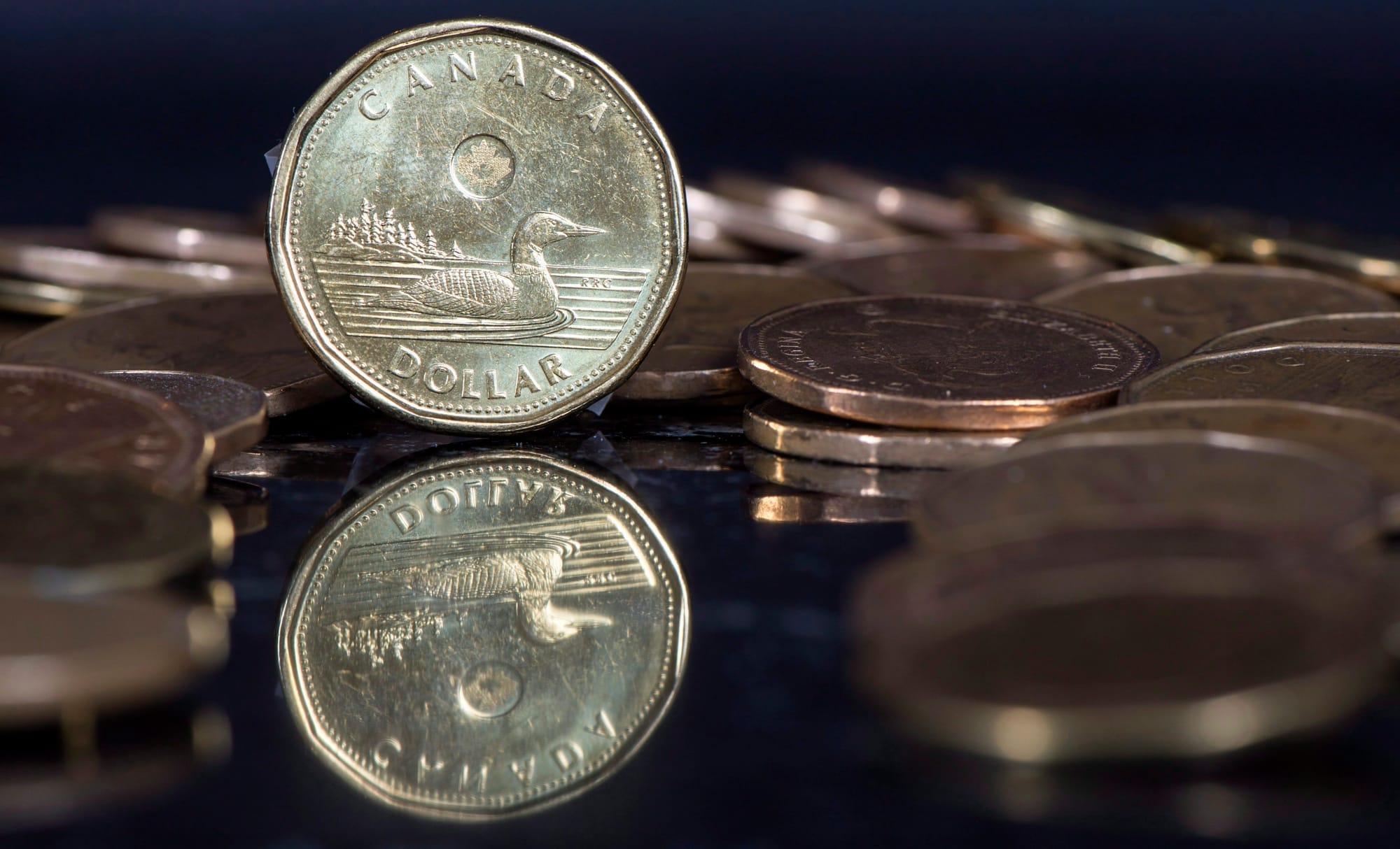 A coin standing on its edge surrounded by other coins.