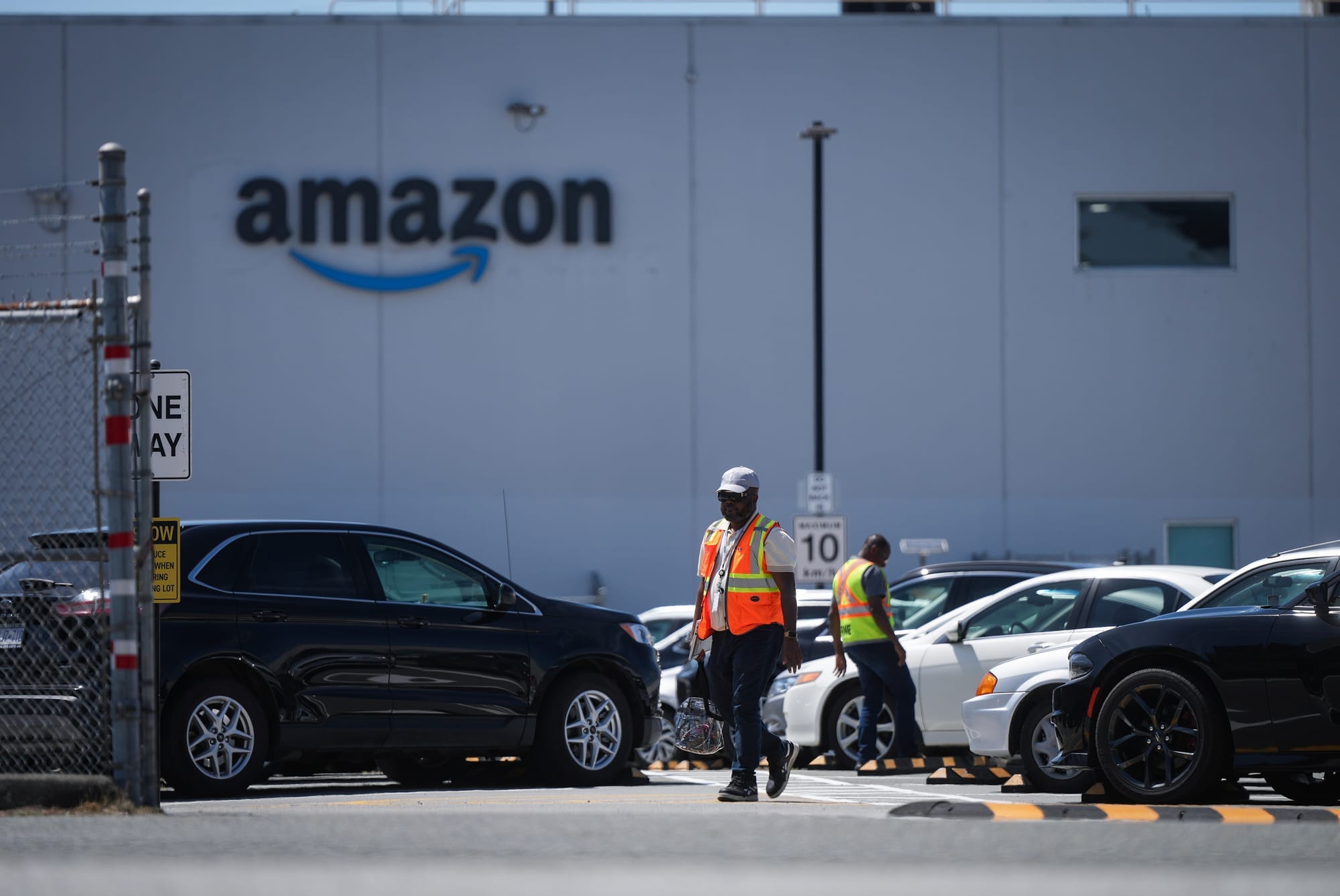 Workers are seen in a parking lot outside Amazon's fulfillment centre in Delta, B.C.