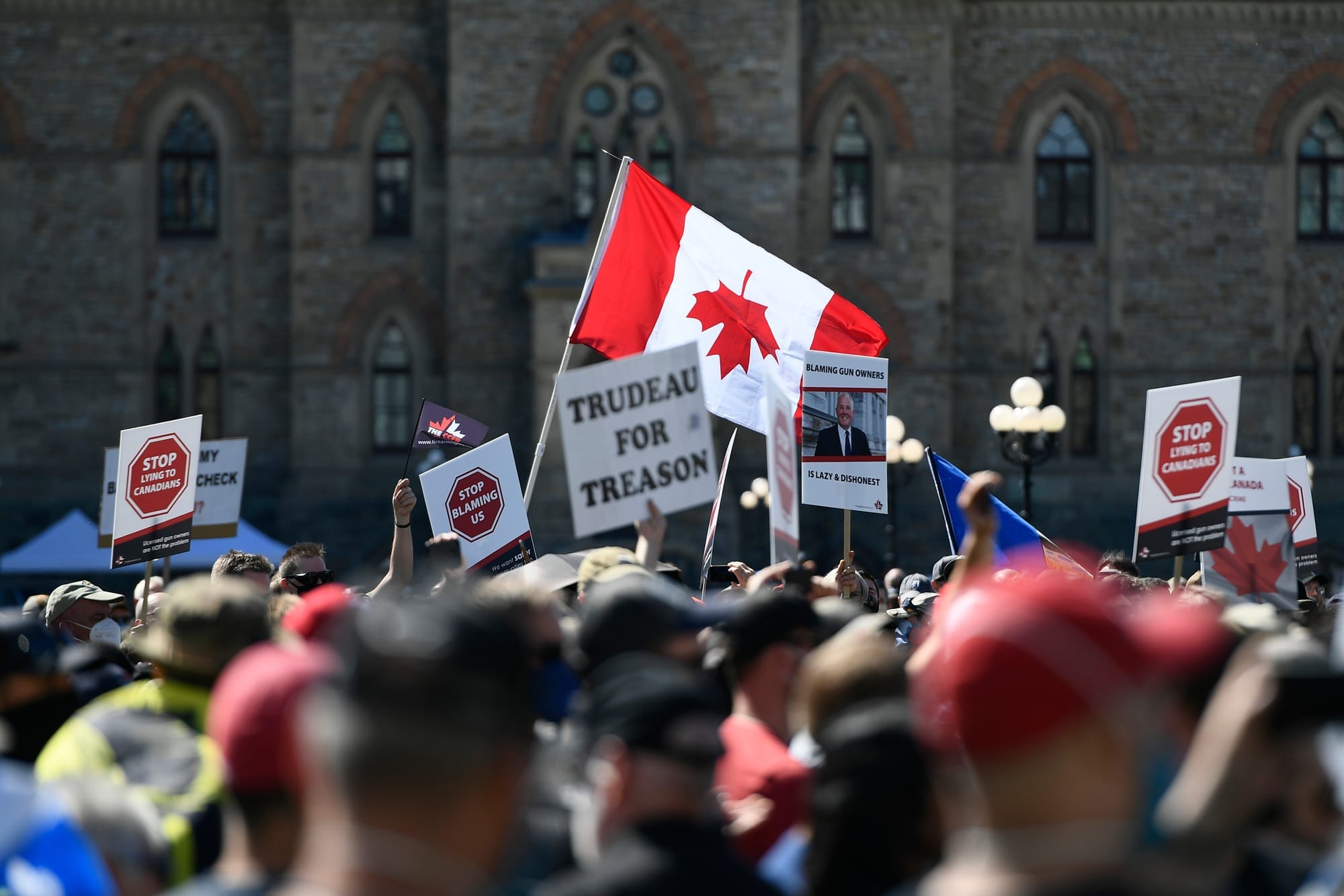 Gun owners hold signs and an upside down Canadian flag at a rally in Ottawa