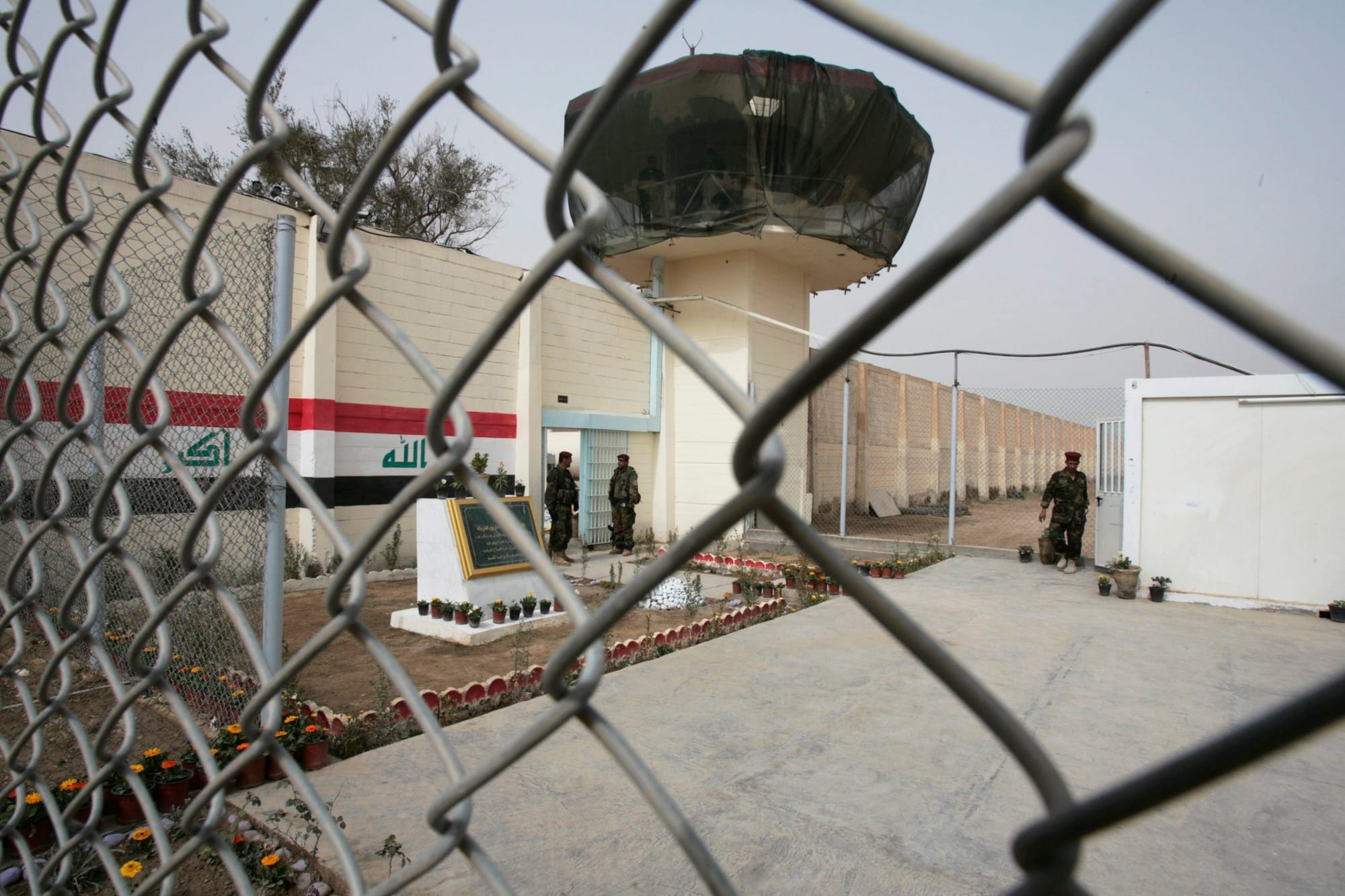 A view of Abu Ghraib prison through a chain link fenc