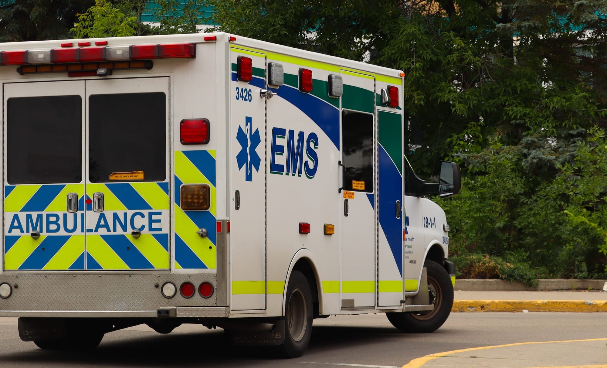 An Alberta Health Services ambulance drives down a street.
