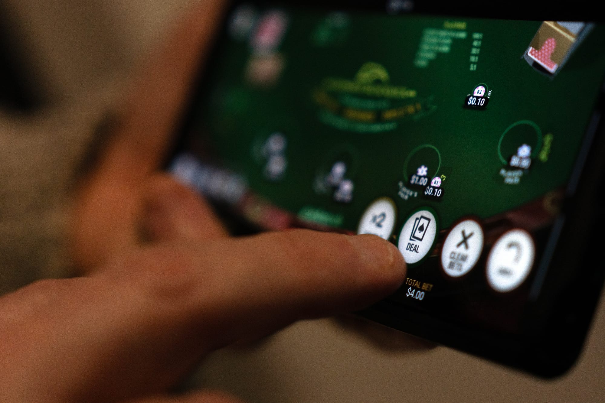 A finger hits a button that says deal on an online gaming app.