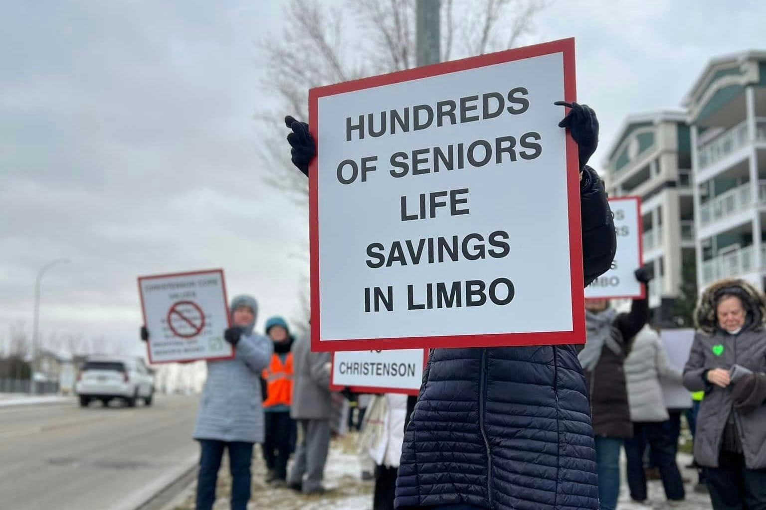 A protestor holds a sign that reads "hundreds of seniors life savings in limbo".