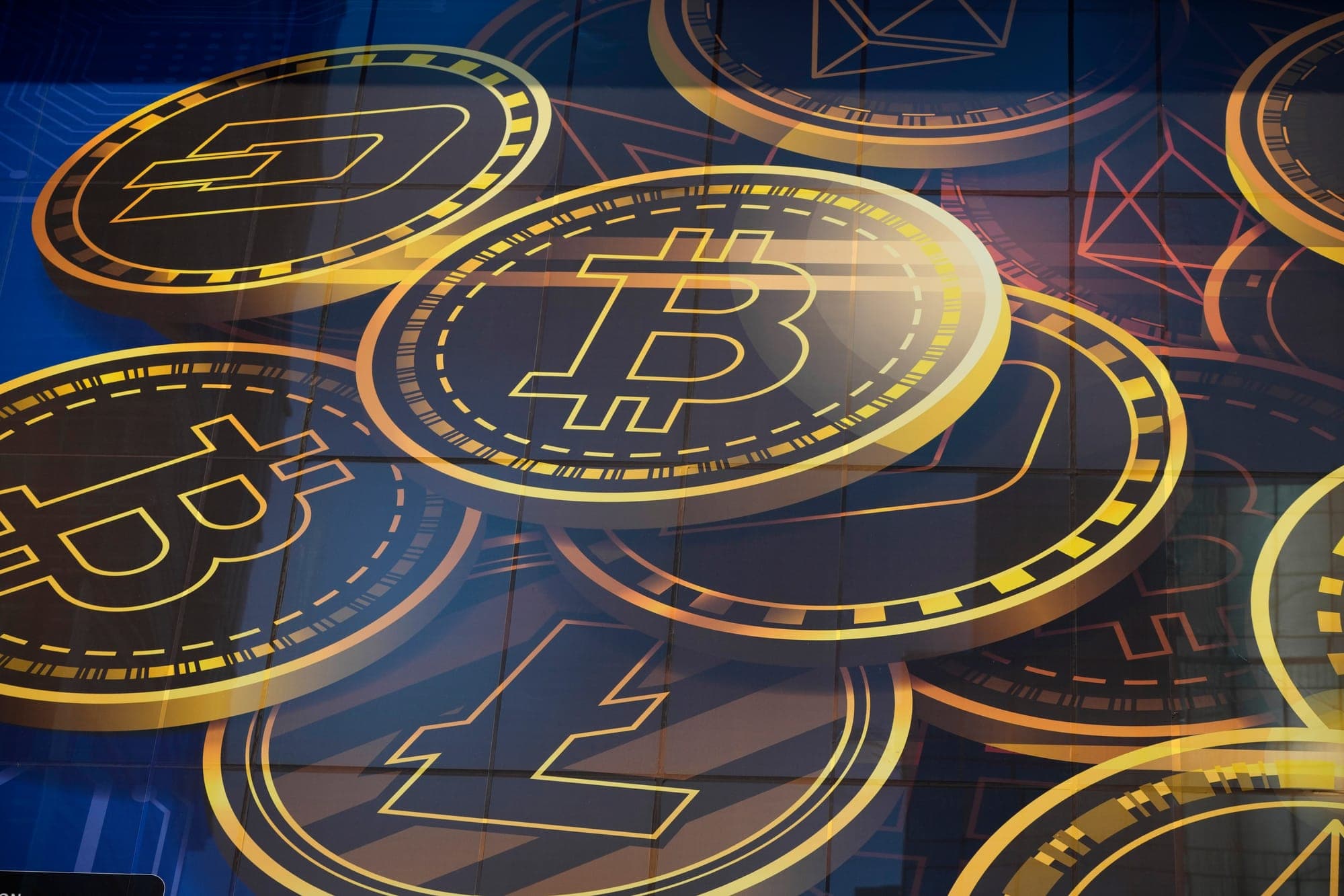 A graphic shows several large gold coins embossed with the Bitcoin logo.